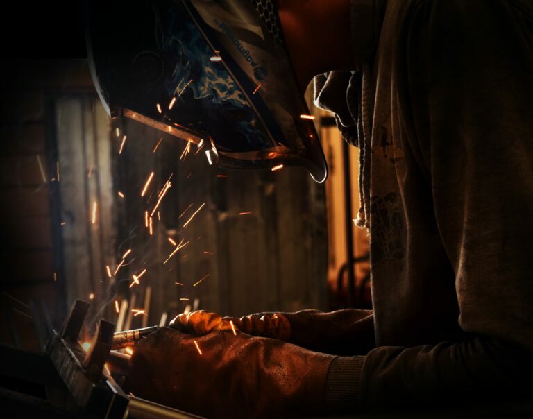 person welding wearing welding helmet